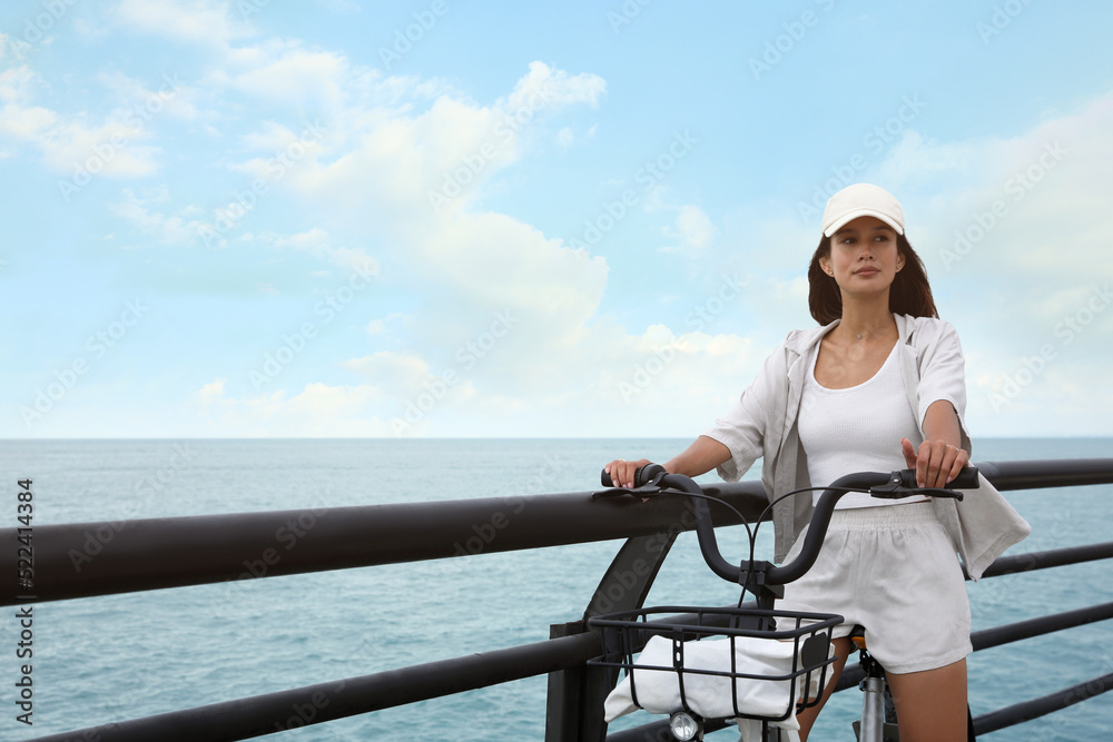 Beautiful young woman with bicycle near sea. Space for text Beautiful young woman with bicycle near sea. Space for text