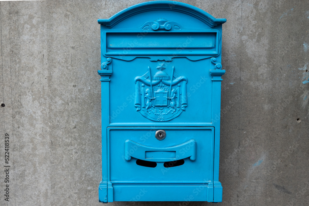 blue old vintage mail box on a street wall