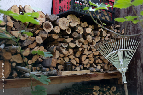 Conceded firewood in a pile. Stacked firewood on a wall behind the house. Ready to burn in the oven or chimney. photo