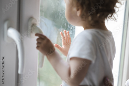 toddler touches the glass at home, fingerprints