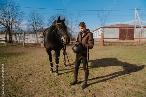 Jockey woman spending time with her horse during equestrian practice