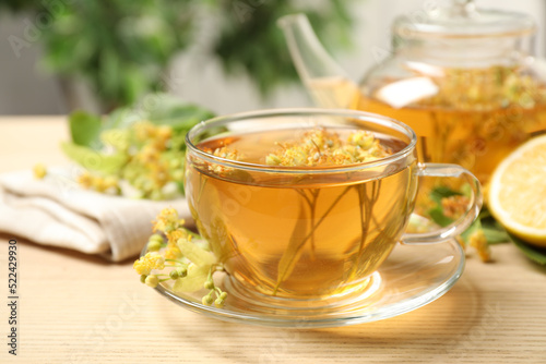 Cup of tea with linden blossom on wooden table