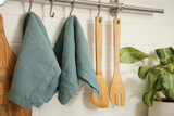 Clean towels and utensils hanging on rack in kitchen