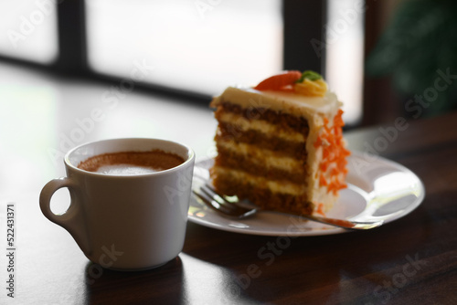 Cup of hot coffee and delicious cake on wooden table, closeup