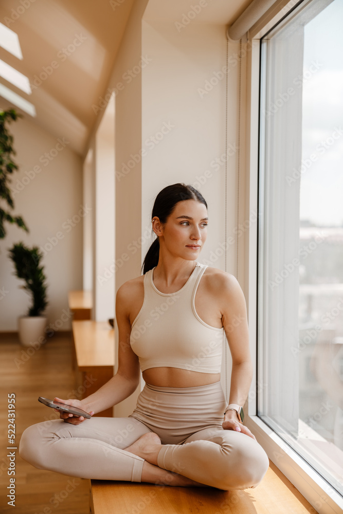 Young white woman using mobile phone during yoga practice Young white woman using mobile phone during yoga practice