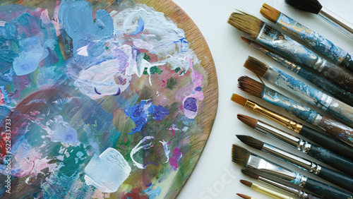 Paint-stained palette and artistic brushes
