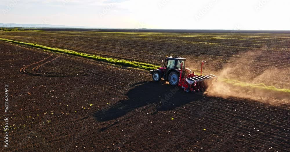 Farmer in tractor seeding soybeans at industrial agricultural farm