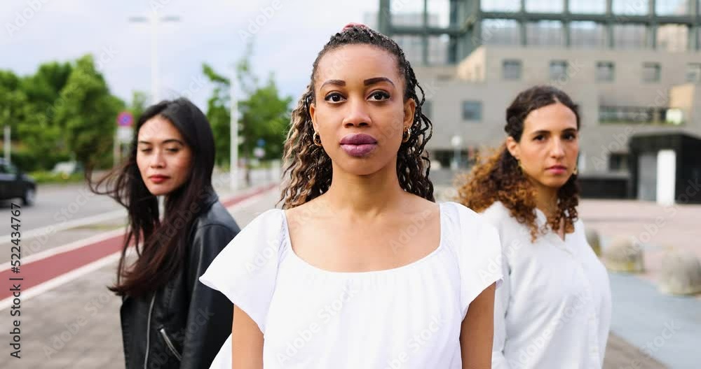 Three beautiful strong women standing in the city looking at camera Three beautiful strong women standing in the city looking at camera