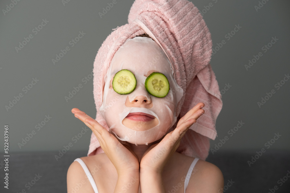 a little beautiful girl is doing spa treatments. Mask with cucumbers on the face