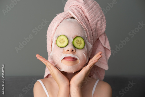 a little beautiful girl is doing spa treatments. Mask with cucumbers on the face