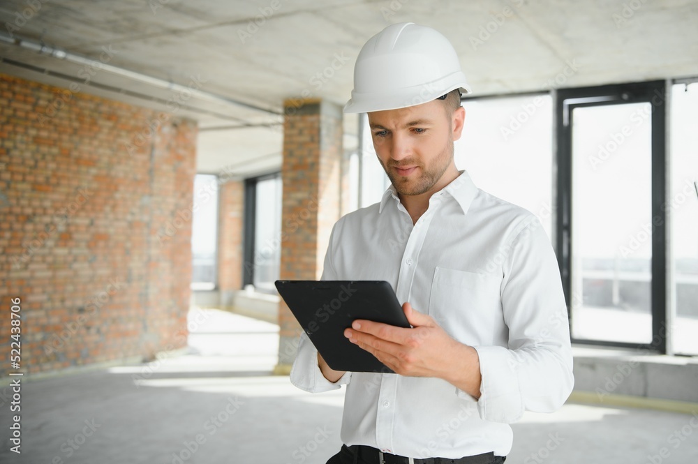 Business architect man wearing hardhat standing of a building project Business architect man wearing hardhat standing of a building project