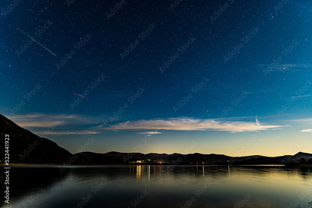 Bassenthwaite lake on a moonlit night with a meteor in the sky from the Perseids meteor shower