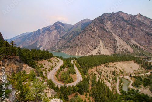 Seton Lake Lookout In Lillooet, B.C. The view on the famous U turn surrounded by beautiful mountain and turquoise lake. Hazy sky.
