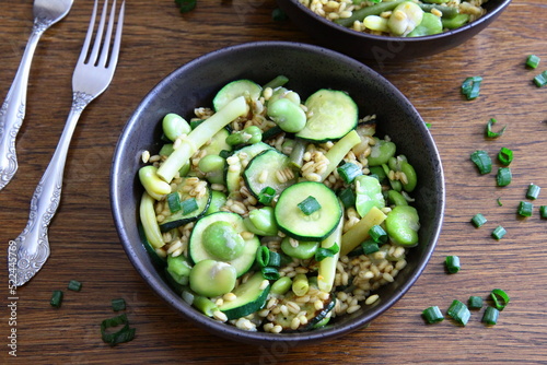 Dish of pearl barley, broad beans, beans and zucchini. Stewed vegetables with porridge. Vegetarian cooking