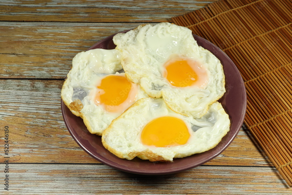 Pile of fried egg serving on the plate. Famous breakfast menu in restaurant. Pile of fried egg serving on the plate. Famous breakfast menu in restaurant.