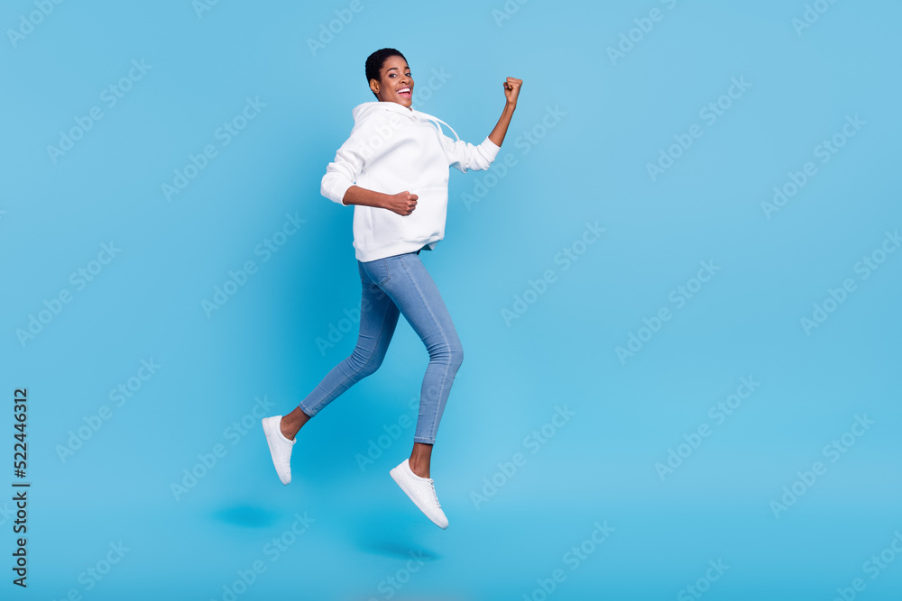 Photo of pretty beautiful unisex lady dressed white hoodie lumping high running fast isolated blue color background