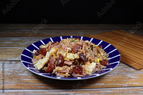 Traditional fried rice with egg and pork sausage serving on the plate. Famous street food menu in Asia. 