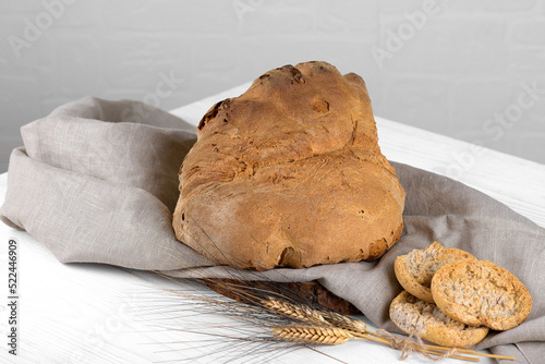 The bread of Matera, Pane di Matera on white wooden background, typical southen italian sourdough bread, the crunchy loaf has the shape of a croissant and is produced with durum wheat semolina