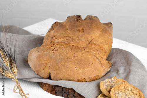 The bread of Matera, Pane di Matera on white wooden background, typical southen italian sourdough bread, the crunchy loaf has the shape of a croissant and is produced with durum wheat semolina photo