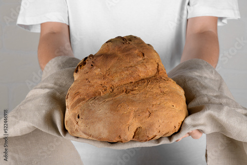 Female hands holding the bread of Matera, Pane di Matera on white background, typical southen italian sourdough bread photo