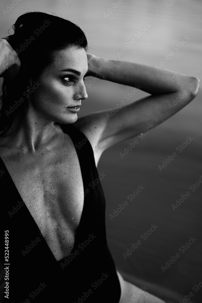 Fototapeta Black White Portrait of Young Woman with Muscular Body in Piece Swimsuit Looking Away.