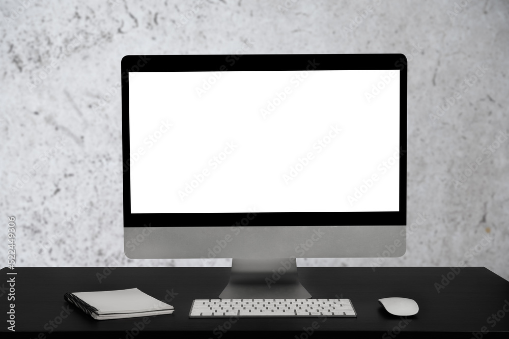 Fototapeta premium Workspace with simulated blank white screen computers and office equipment on a wooden table.