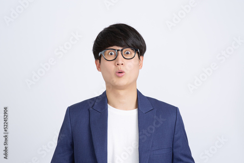 Photogenic portrait of excited Asian businessman with wide open eyes isolated white background