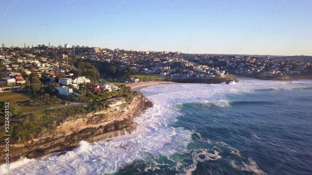 Aerial static shot of Bronte Beach and Waterfont neighborhood properties with Sydney CBD skyline view in the horizon Aerial static shot of Bronte Beach and Waterfont neighborhood properties with Sydney CBD skyline view in the horizon