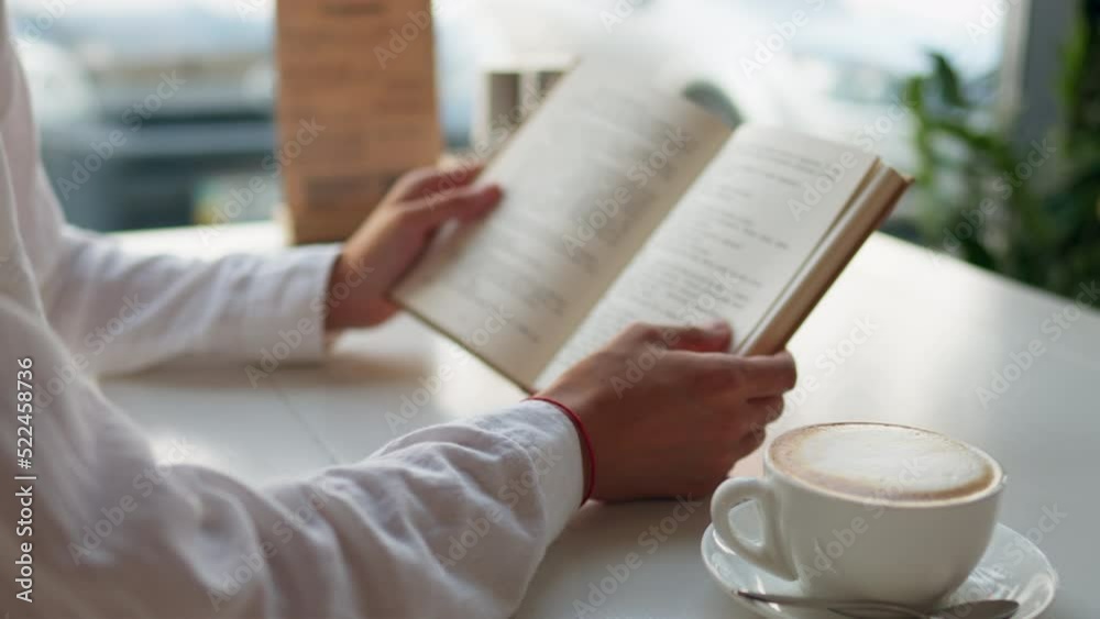 A focused girl reads a book absorbed in telling a story sits in a restaurant drinking fresh coffee with milk. A cup of coffee stands on a wooden table, the girl is resting while reading a book slowly
A focused girl reads a book absorbed in telling a story sits in a restaurant drinking fresh coffee with milk. A cup of coffee stands on a wooden table, the girl is resting while reading a book slowly