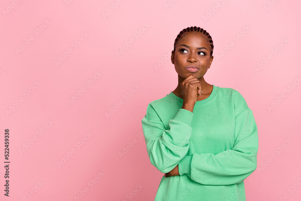 Photo of minded charming lady arm touch chin look interested empty space isolated on pink color background Photo of minded charming lady arm touch chin look interested empty space isolated on pink color background