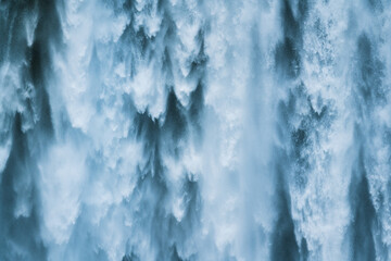 Powerful large natural waterfall flowing from cliff in summer