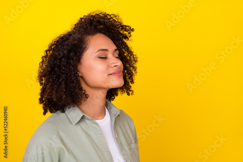 Profile photo of cute curly millennial brunette lady smell promo wear grey shirt isolated on yellow color background photo