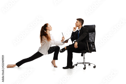 Co-workers. Two stylish office workers in business suits in action isolated on white background. Art, beauty, fashion and business concept