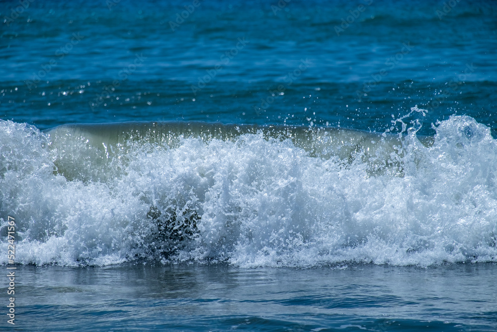Ocean waves crashing on sandy beach. Sea waves breaking on Maditerranean's shore. Ocean waves crashing on sandy beach. Sea waves breaking on Maditerranean's shore.