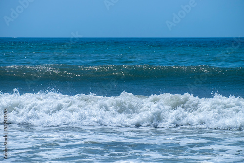 Ocean waves crashing on sandy beach. Sea waves breaking on Maditerranean's shore.
