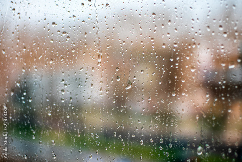 Raindrops on window glass. Rainy city background. Rainy autumn weather