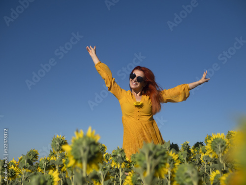 Happy woman in field with blooming sunflowers