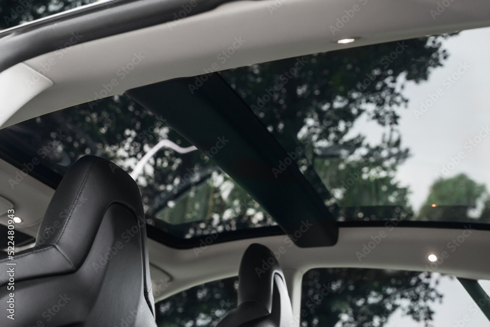 Fototapeta premium Panoramic glass sunroof in the car. Clean glass and view from inside to the sky