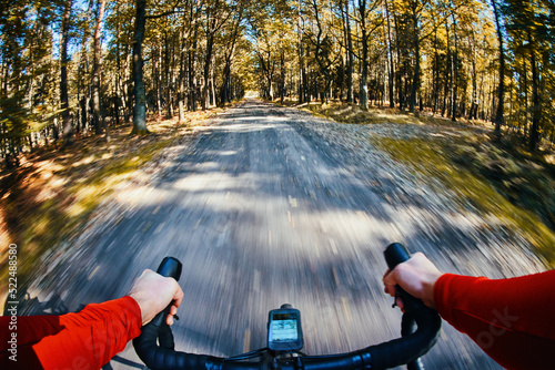 POV picture of man riding gravel bike in forest during autumn fall 