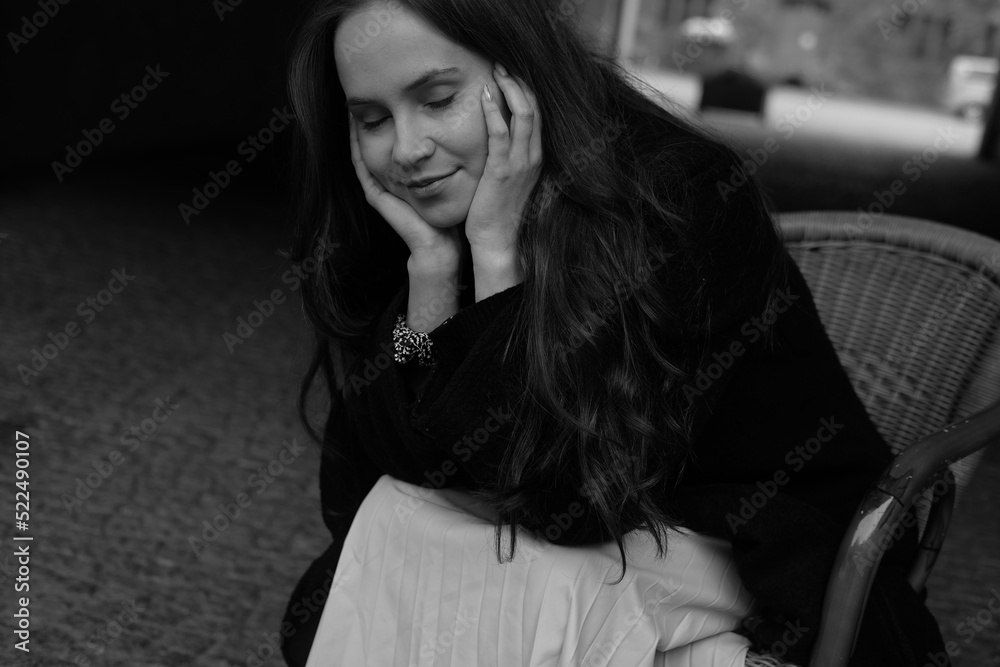 Sensual portrait of a young brunette in a white dress. Girl in a autumn wear is sitting in a chair Sensual portrait of a young brunette in a white dress. Girl in a autumn wear is sitting in a chair
