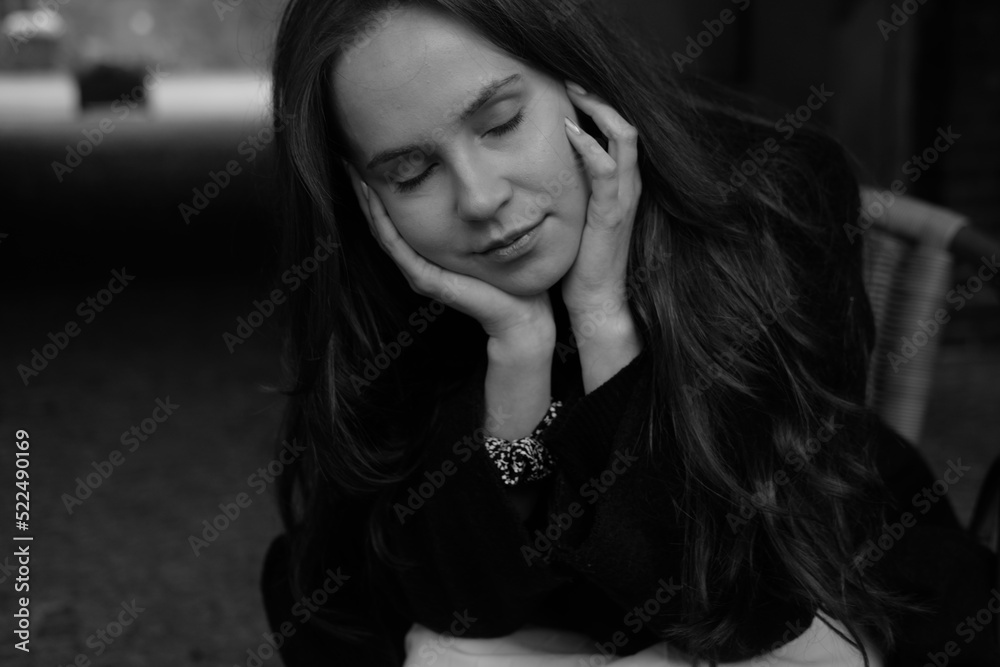 Sensual portrait of a young brunette in a white dress. Girl in a autumn wear is sitting in a chair 