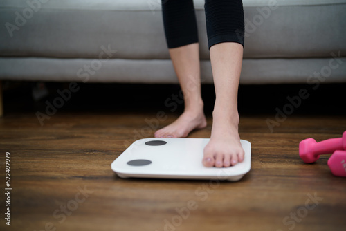 Fat diet and scale feet standing on electronic scales for weight control. Measurement instrument in kilogram for a diet control