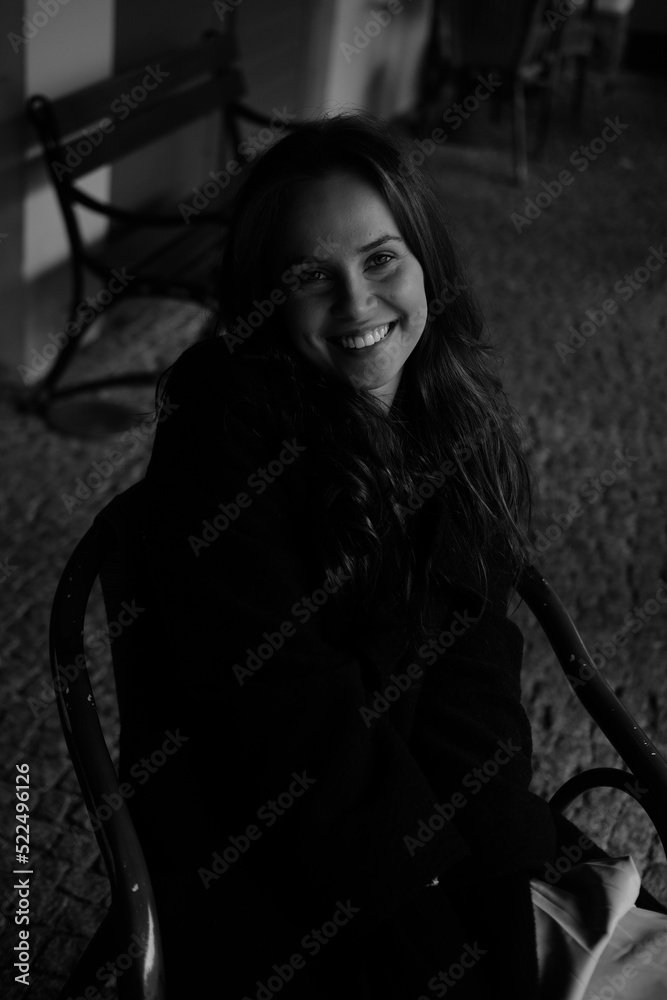 Sensual portrait of a young brunette in a white dress. Girl in a autumn wear is sitting in a chair Sensual portrait of a young brunette in a white dress. Girl in a autumn wear is sitting in a chair