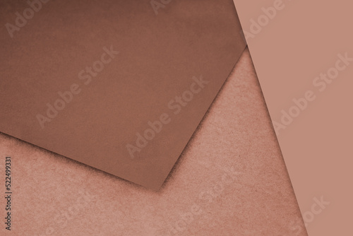 Plain and Textured pastel brown papers randomly laying to form M like pattern and triangle for creative cover design idea