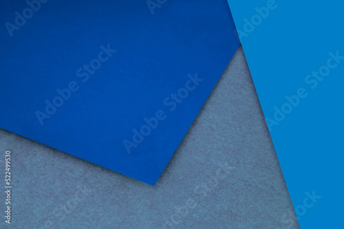 Plain and Textured neon blue grey purple papers randomly laying to form M like pattern and triangle for creative cover design idea