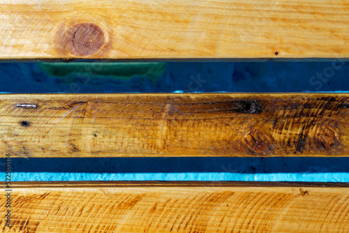 closeup of wood boards impregnated with linseed oil varnish of ponds bench shining in the sunlight photo