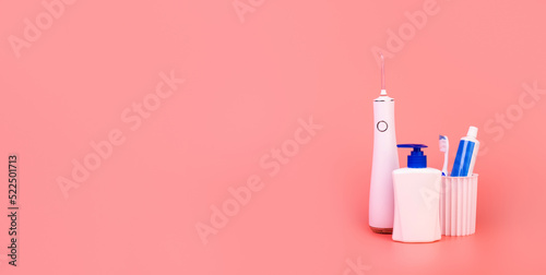 composition with manual toothbrush, irrigatoro, toothpaste, oral hygiene products and soap on colored background. oral care concept. hygiene concept