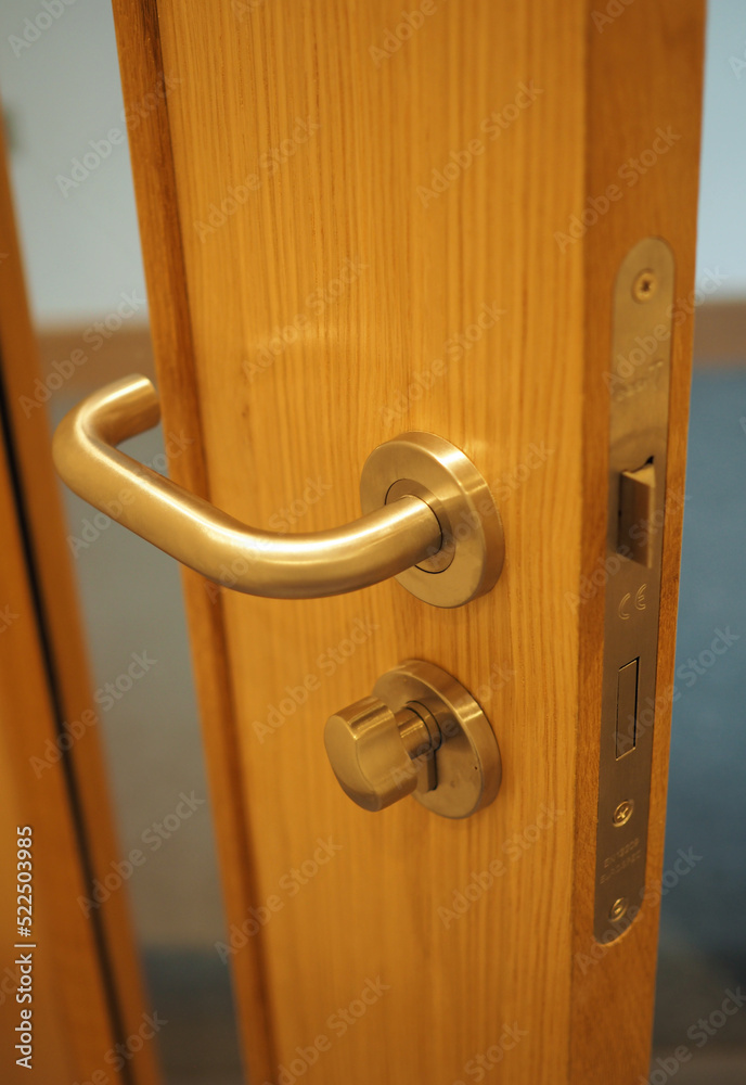 Obraz premium Chrome door handle with twist lock on wooden door