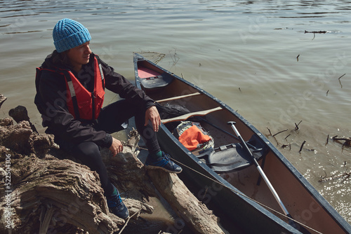 Man paddling in a canoe on a Danube river in urban area, small recreational escape, hobbies and sports outdoors.