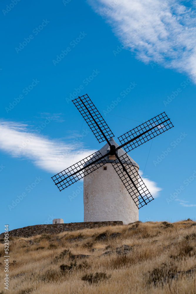 Beautiful wind mill isolated in top of a hill near to Consuegra city in Castilla-La Mancha - Spain. Cloudy day.